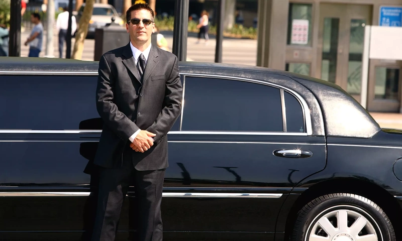 Professional chauffeur standing beside a luxury limousine for Orland Park limousine service to O'Hare and Midway Airport