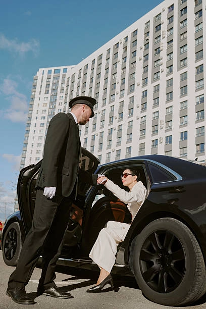 Airport Transportation Chicago chauffeur assisting passenger from a luxury black car outside hotel.
