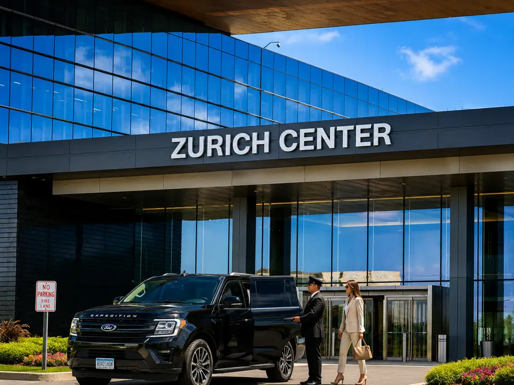 Luxury chauffeur opening the door of a black Ford Expedition for a business executive at Zurich Center, providing premium executive transportation and corporate chauffeur service.